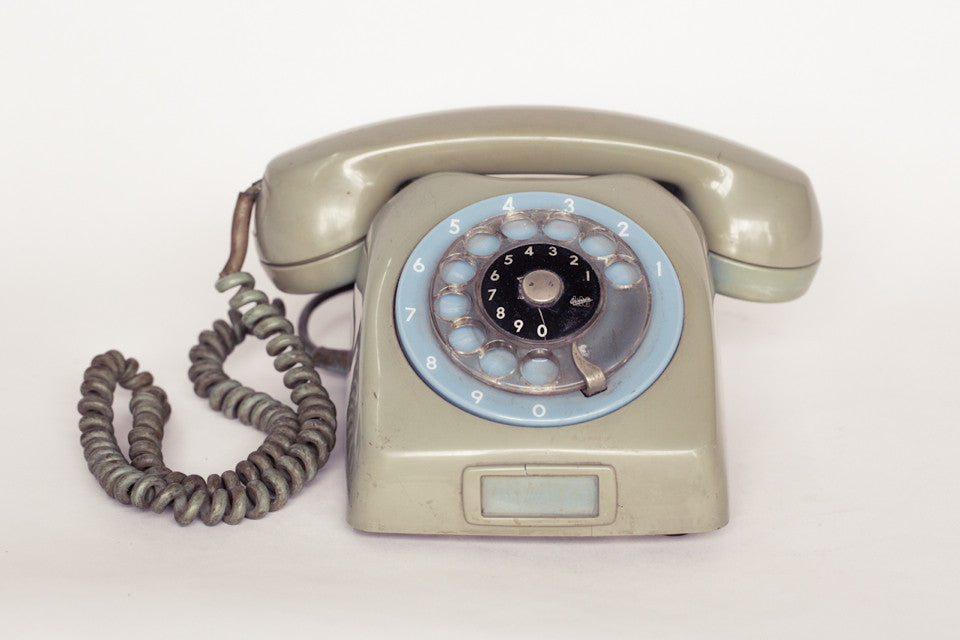 1980s retro telephone in dirty green with baby blue dial.